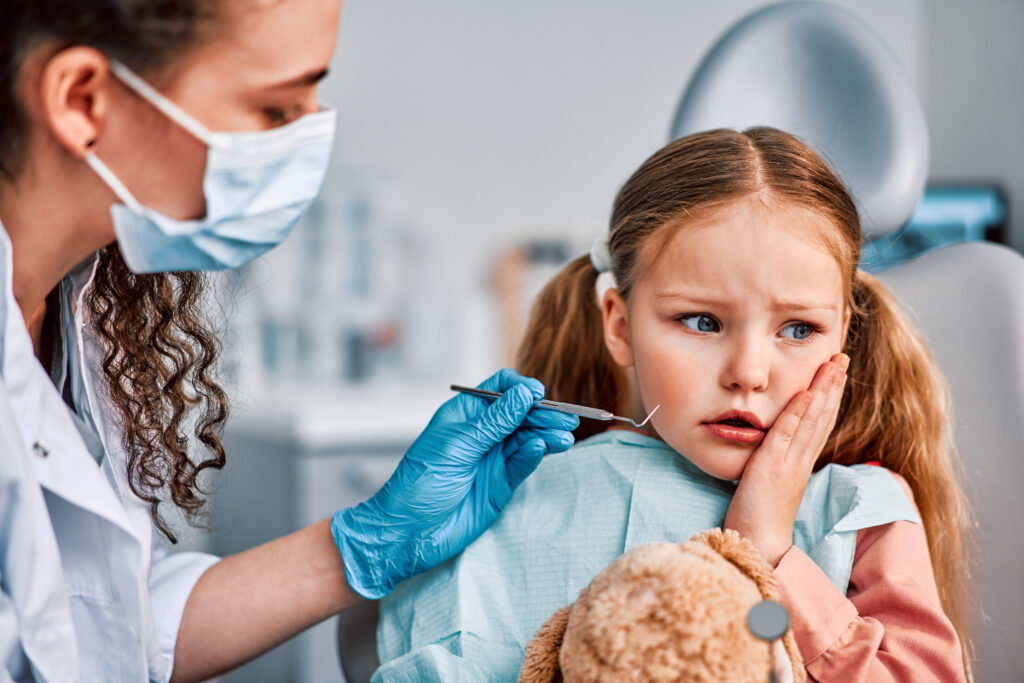 Child with tooth pain at dental clinic being examined by a kids emergency dentist in Highland